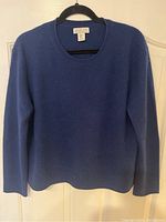 Front view of blue Rachel Zoe cashmere sweater on hanger, shows crew neck and long sleeves