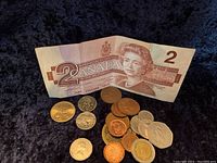 Overview of two Canadian $2 bills and assorted coins including two Indian Head nickels