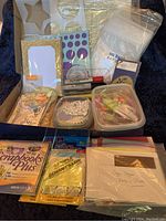 Full overview of the craft lot showing cards, ribbons, markers, note tabs, stencils, plastic bags, and software packages.