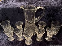 Full set of one pitcher, seven liqueur or sherry glasses, and two tumblers displayed on black velvet background.