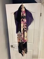 Five ladies' scarves, shawls and coverups hanging, showcasing the floral Calvin Klein stole alongside the purple chiffon coverup and the black chiffon poncho-like coverup.
