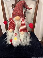 Front view of all four decorative gnomes arranged together showing hats and beards.