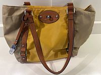 Franco Sarto handbag showing front view with beige and ochre fabric and brown leather handles and trim