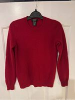 Full front view of the red cashmere sweater showing overall condition and style