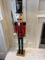 Front view of the 36 inch tall wooden nutcracker showing detailed face, red jacket with gold buttons, green pants, and black tall hat with gold design.