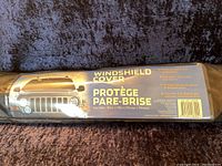 Photo of the product packaging with specifications and usage details on the windshield cover for cars, trucks, and SUVs.