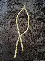 Full view of the gold-tone rhinestone necklace with two dangling ends forming a Y-shape.