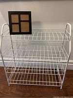 Shoe rack showcasing its sturdy wire shelves in white coating.