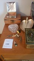 Photo of various jewellery boxes and pins placed on a wooden surface.