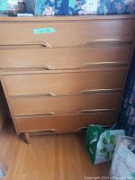 Front view of dresser showing five drawers, tapered legs, and integrated drawer pulls