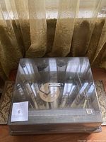 View of the record player with clear dust cover closed, showing the Concerto label on top and wood base.