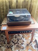 Side table top surface holding a turntable with dust cover. The table is wooden and measures around 25 x 18.5 x 20.5 inches.
