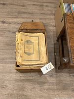 Top-down photo of wooden box filled with worn sheet music books, Chopin title visible