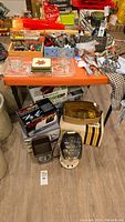 Overview of lot on folding table showing appliances on floor and bakeware on top