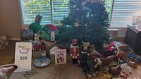 Wide view of Christmas decorations around an artificial Christmas tree, various boxes and wrapped items visible.