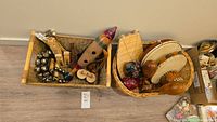 Two woven baskets filled with assorted musical instruments including tambourines, maracas, bells, wooden flutes, and shakers.