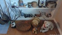 Overview of shelf with small pottery, figurines and floor display