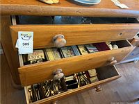 Image showing wooden drawers slightly open, with silverware visible inside the bottom drawer and other household items in upper drawers