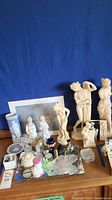 Main overview of lot showing classical statues, vases, figurines and decorative items