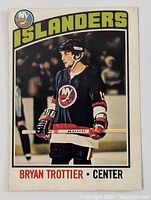 Front of the 1976-77 OPC Bryan Trottier rookie card showing Trottier in New York Islanders uniform with team logo and 'ISLANDERS' header.