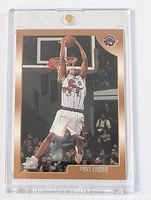 Front view of Vince Carter rookie basketball card showing the player mid-dunk action in a Raptors white uniform with Topps Rookie Card logo and Raptors logo visible.