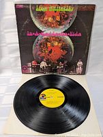 Vinyl LP record with yellow ATOC label and original cover laid flat, showing record surface and label.