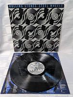 Front cover of Rolling Stones Steel Wheels vinyl LP showing stylized black and gray wheel pattern.