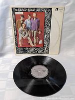 Photo of the Beach Boys vinyl LP record and its outer cover, showing the vinyl disc and front side of the album jacket with band members' photo and decorative border.