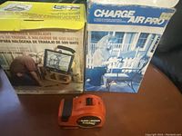 Three tools displayed: two boxed lights (one Air Pro 500W halogen work light, one Air Pro light) and a Black & Decker automatic tape measure in front