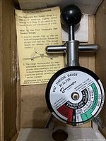 Photo of Boroughs Belt Tension Gauge model BT133-750 inside original box with printed operating instructions visible.