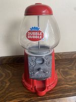 Front view of Dubble Bubble candy/gumball machine with coin mechanism and cast iron base, showing logo and coin slot.