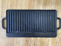 Top view of griddle showing ridged grill side with two side handles.