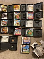 Nintendo DS game cases laid out containing various games with some empty cases.