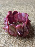 Close-up front view of the vintage pink abalone shell bracelet showing the large, polished shell pieces and elastic band.