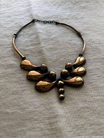 Front view of the copper necklace showing teardrop and spherical elements