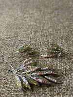 Front view of vintage enameled leaf brooch and matching earrings showing detailed green, pink, and white enamel on silver-tone metal.