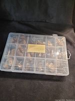 Closed plastic compartment box with multiple small animal figurines inside, some visible through top.