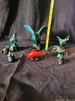 Overall view of five Blue Mountain Pottery animal figurines on a black cloth with measuring tape showing around 6-7 inches tall for the largest.