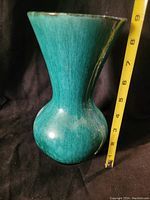 Front angle view of turquoise glazed pottery vase showing shape and texture with measuring tape indicating height around 9 inches.