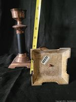 Two vintage brass candle holders shown side by side against a black background with a tape measure indicating height of approximately 7 inches.