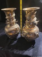 Pair of brass dragon vases side by side with ruler showing height