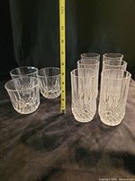 Photo showing two short and six tall crystal glasses arranged on black fabric with a measuring tape indicating height approx 4-6 inches