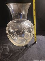 Side view of the large glass vase showing floral etched design and measurement tape indicating height around 9 inches.