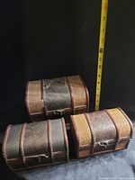 Three decorative treasure boxes: one large with visible damage, two small in good condition, set against black background with measuring tape showing widths.