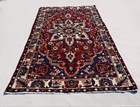 Full view of rug laid flat showing floral medallion pattern and border