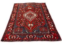 Full view of the rug laid out showing overall geometric pattern in red, navy, white and blue with patterned borders