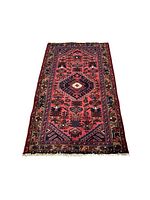 Full length view of Persian Zanjan rug, showing entire geometric and tribal pattern and color scheme, laid flat on floor