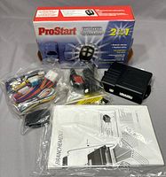 Box and all components laid out including wiring, control module, remote fob, and manual