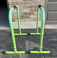 Front view of two bright green Lebert Equalizer Bars showing stable base and foam grips.
