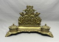Front view of the vintage ornate double inkwell letter holder showing details of lids and decorative filigree work